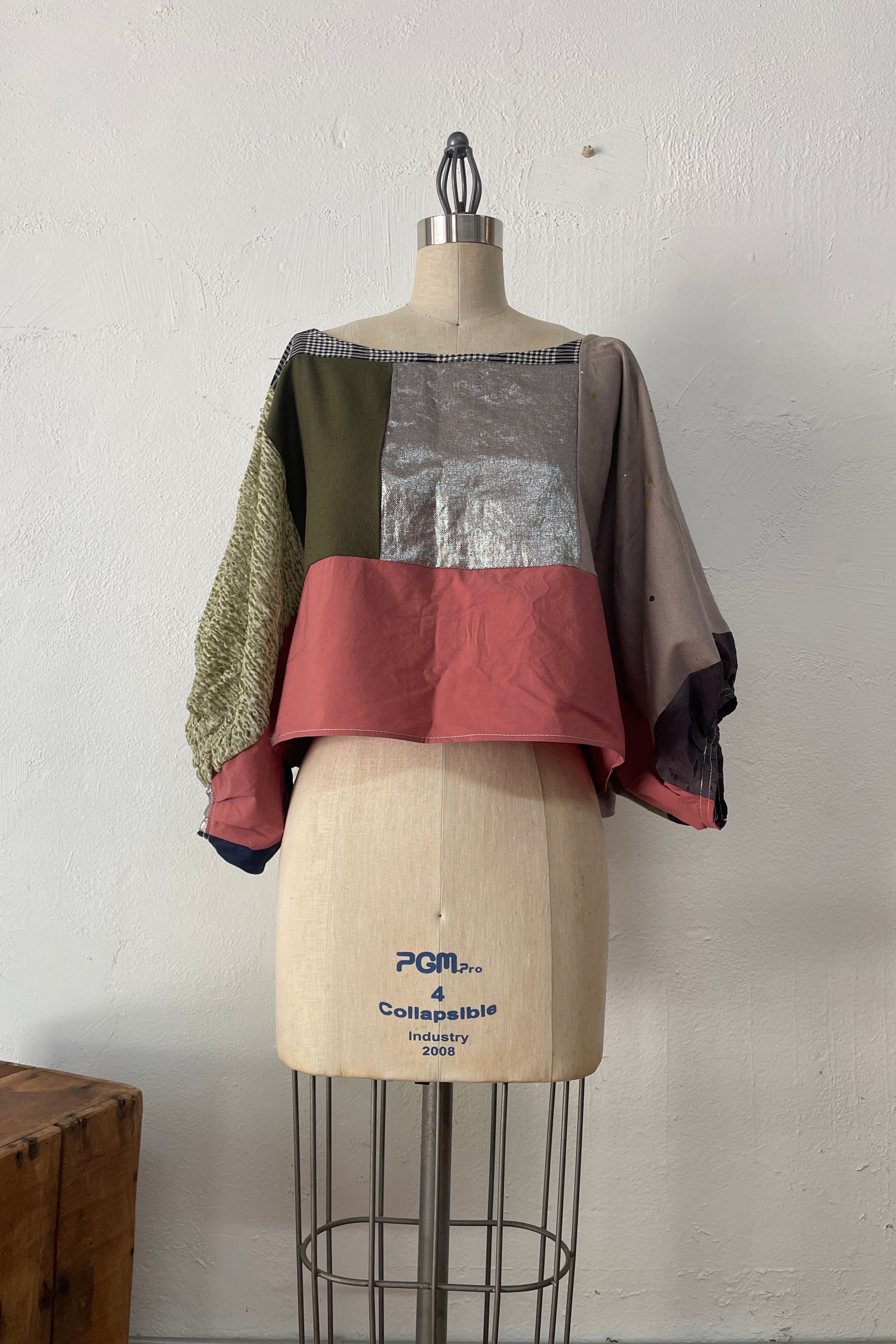 Color-blocked top on a mannequin  against a white wall